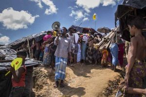 An NGO worker uses a Unicef supplied bullhorn to alert camp dwellers of access to the cholera vaccine that is being given in the tent behind him. Unicef supplies vaccines for a massive cholera vaccination campaign targeting all Rohingya refugees arrived in Bangladesh, on the 10th of October 2017. In Shafullarkata refugee camp vaccinators working in small groups deliver the oral vaccine in outreach points within the camp.
